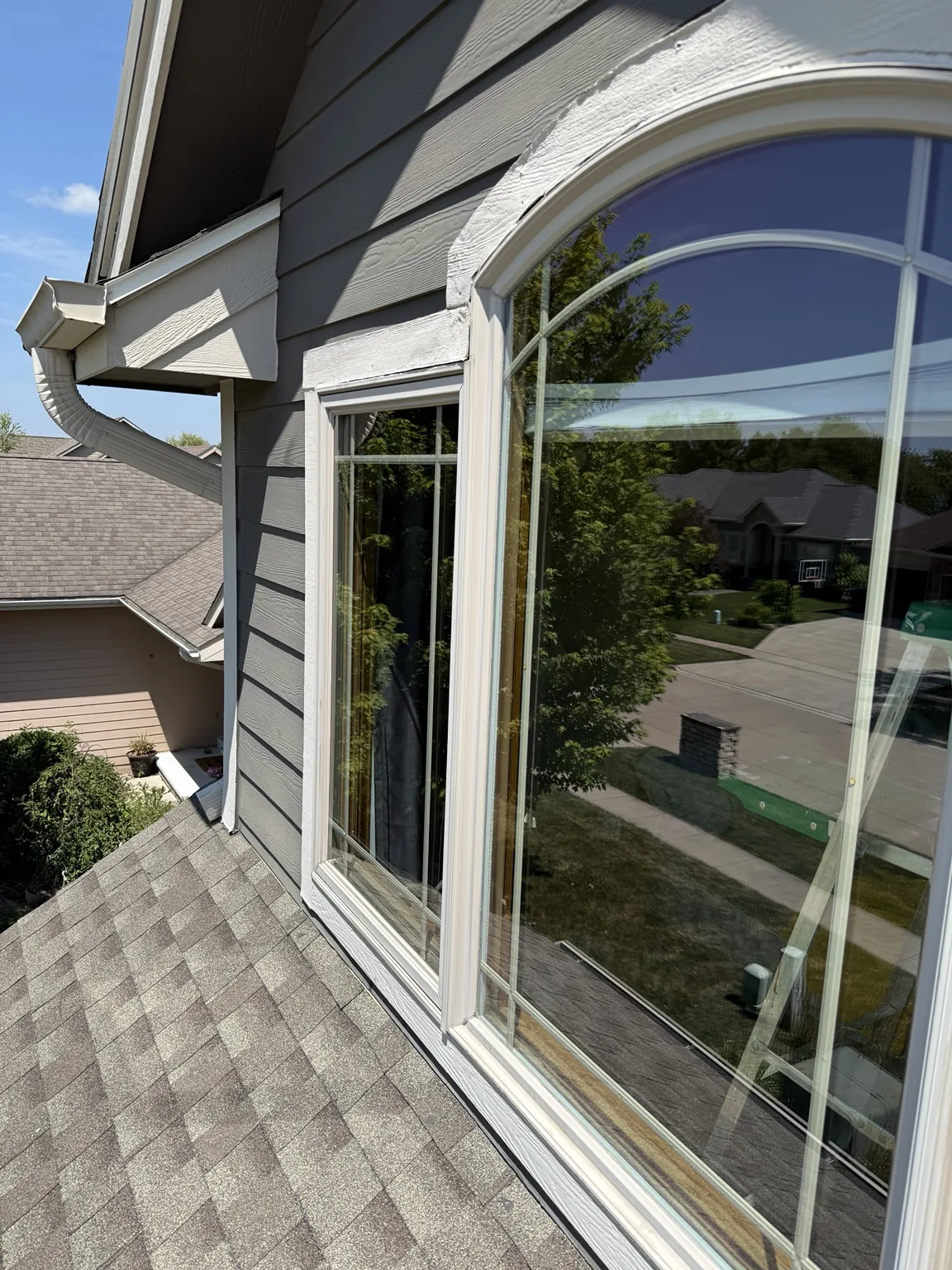 Clean arched second-story window after exterior cleaning